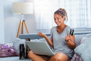 Young beautiful woman happy for finding shopping items for sale online. Beautiful girl using laptop computer for online shopping at home