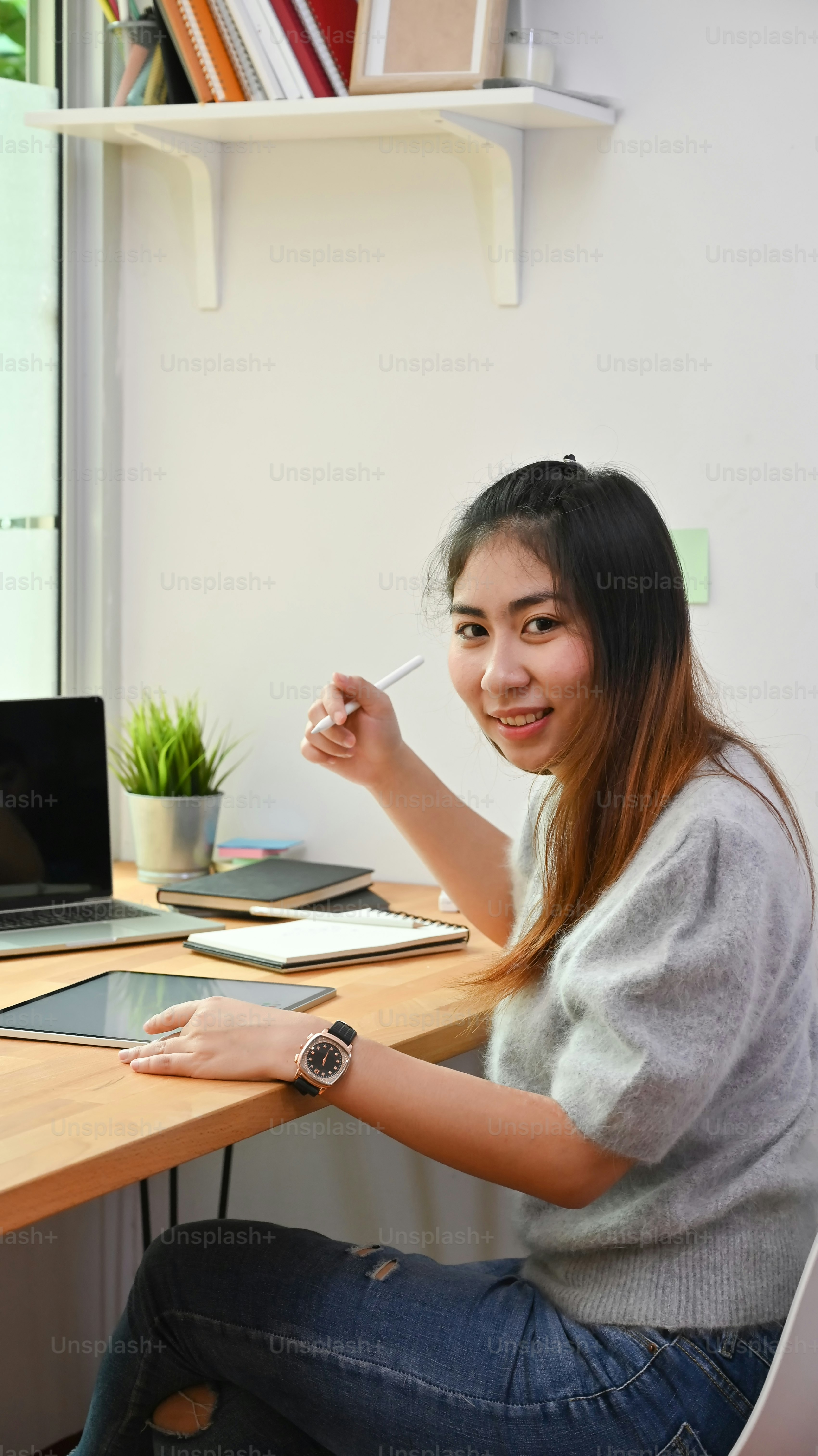 Portrait shot of young creative woman sitting on workplace.