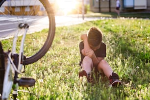십대 소년 자전거를 타다가 넘어져 무릎 부상이 있습니다. 아이는 자전거에서 떨어져 다리를 다쳤습니다. 자전거 타는 법을 배우는 아이