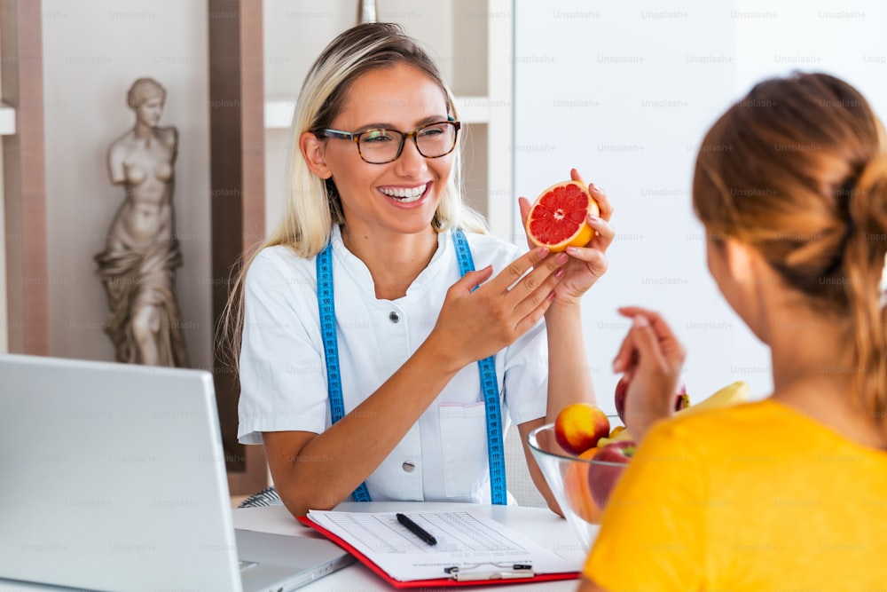 Female nutritionist giving consultation to patient. Making diet plan. Young woman visiting nutritionist in weight loss clinic