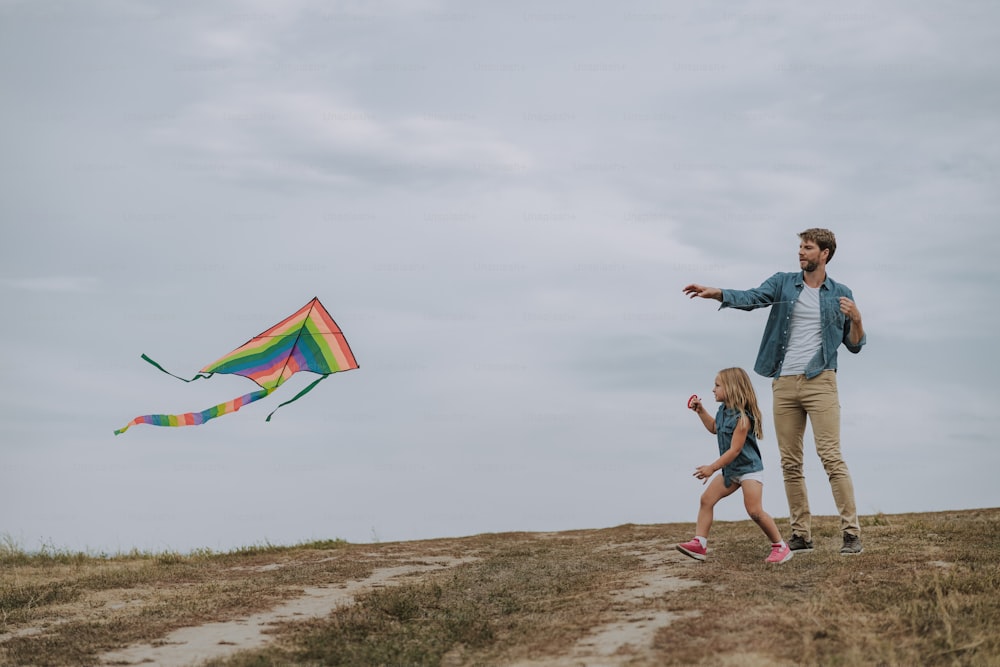 Father and daughter launching a kite stock photo
