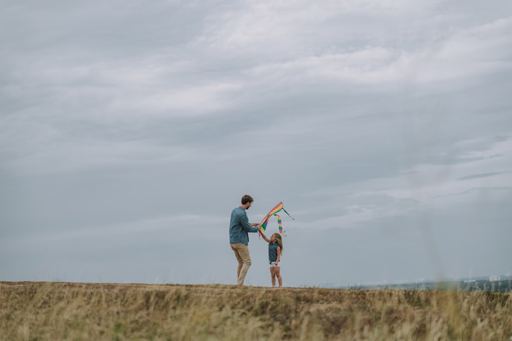 Dad and daughter holding kite outdoors stock photo