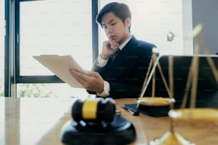 Justice and lawfirm concept. Male lawyer in the office with brass scale.