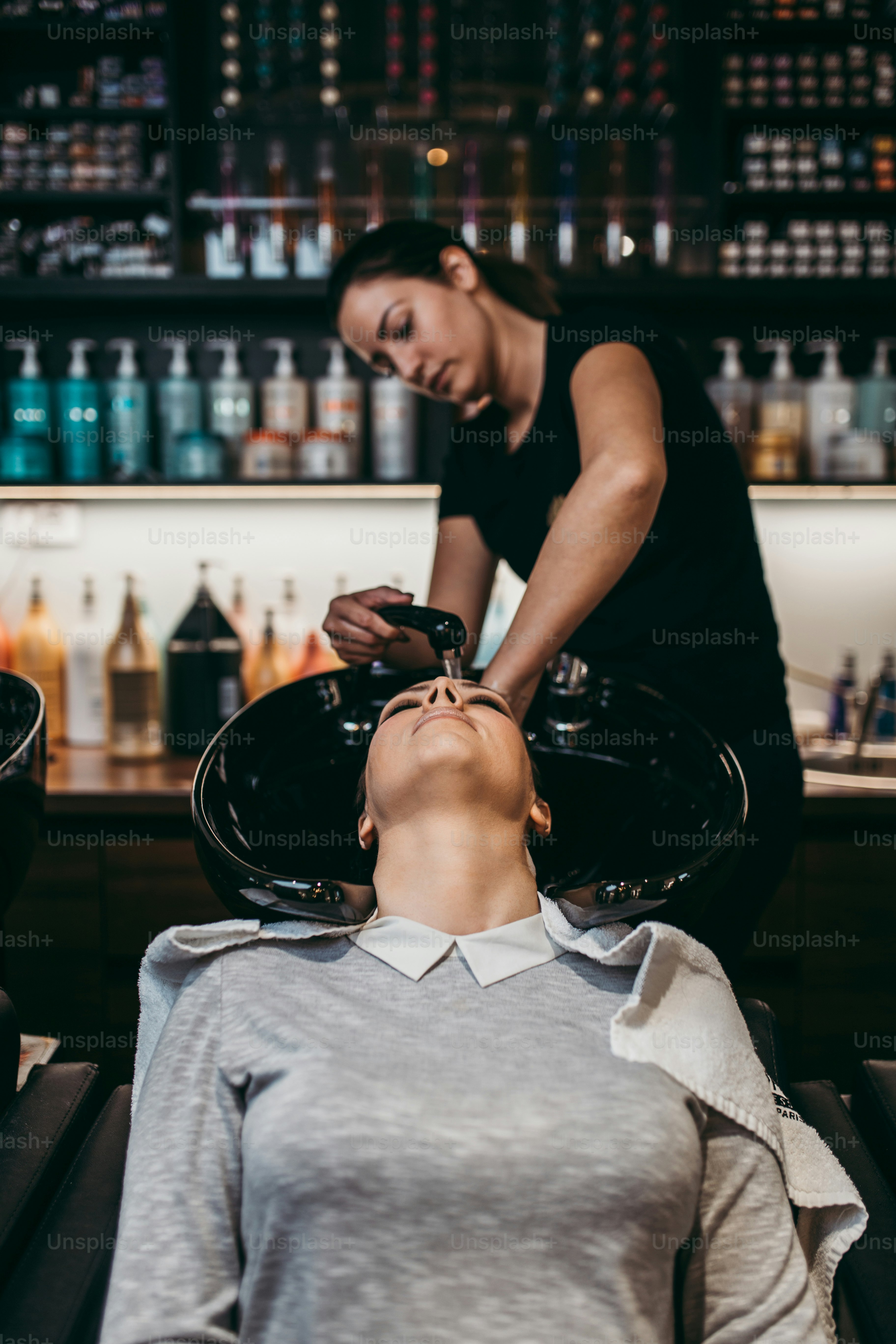 Schöne junge Frau, die eine Haarwäsche bekommt. Friseursalon-Styling-Konzept.