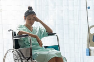 Paciente grave sentado en silla de ruedas en la sala del hospital. Los malos resultados de salud hacen que el paciente sea infeliz. Concepto de negligencia médica.