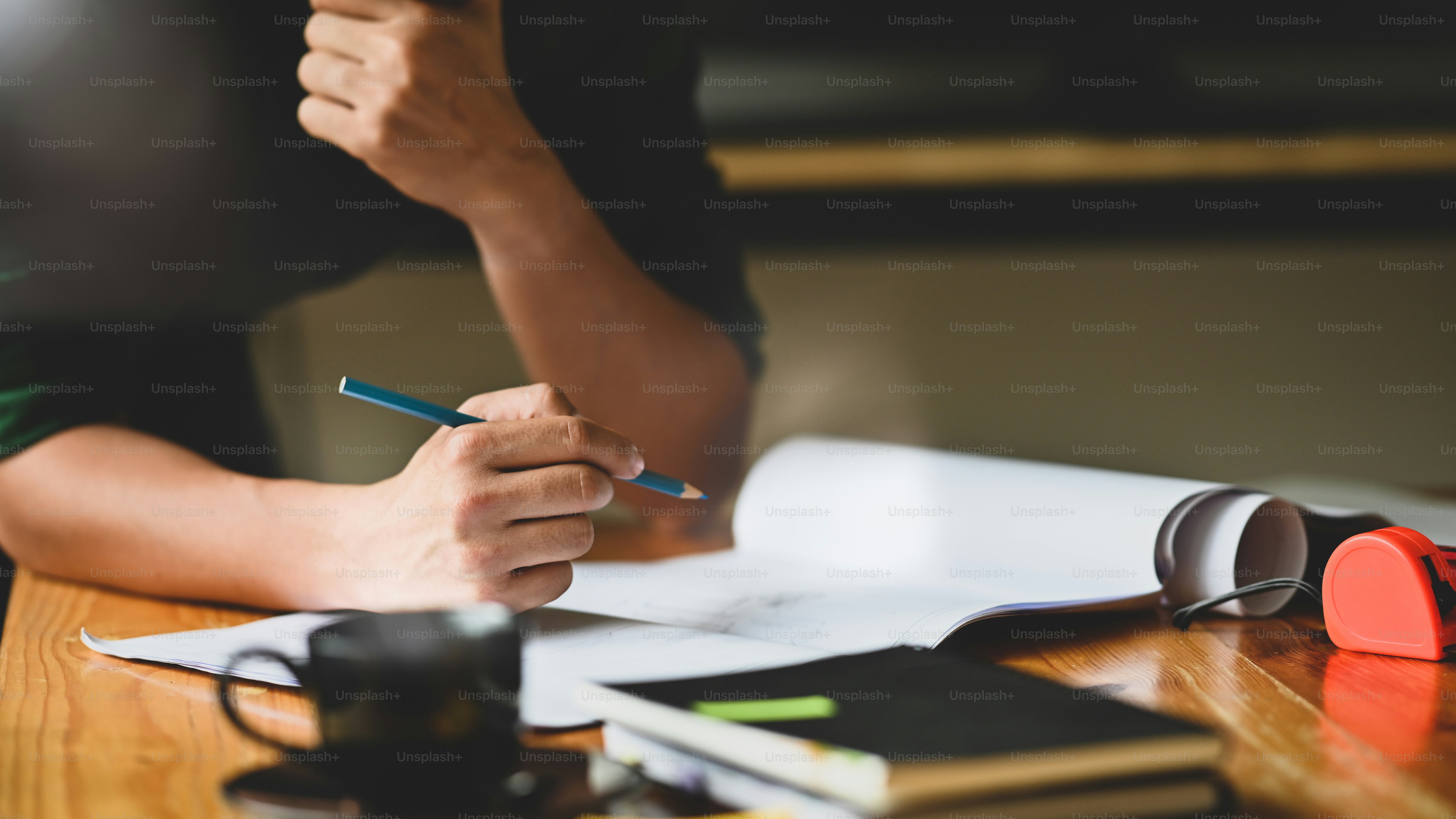 Closeup architecture man working with blueprints on architect table.