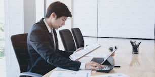 Contador do sexo masculino analisando e revisando os gastos de sua empresa na sala do escritório