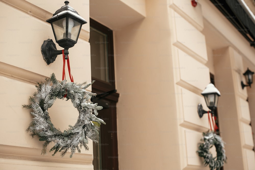 Decoração de rua de Natal. Elegantes coroas rústicas de Natal na lanterna na loja da frente no mercado de férias na rua da cidade. Espaço para texto. Decoração rústica