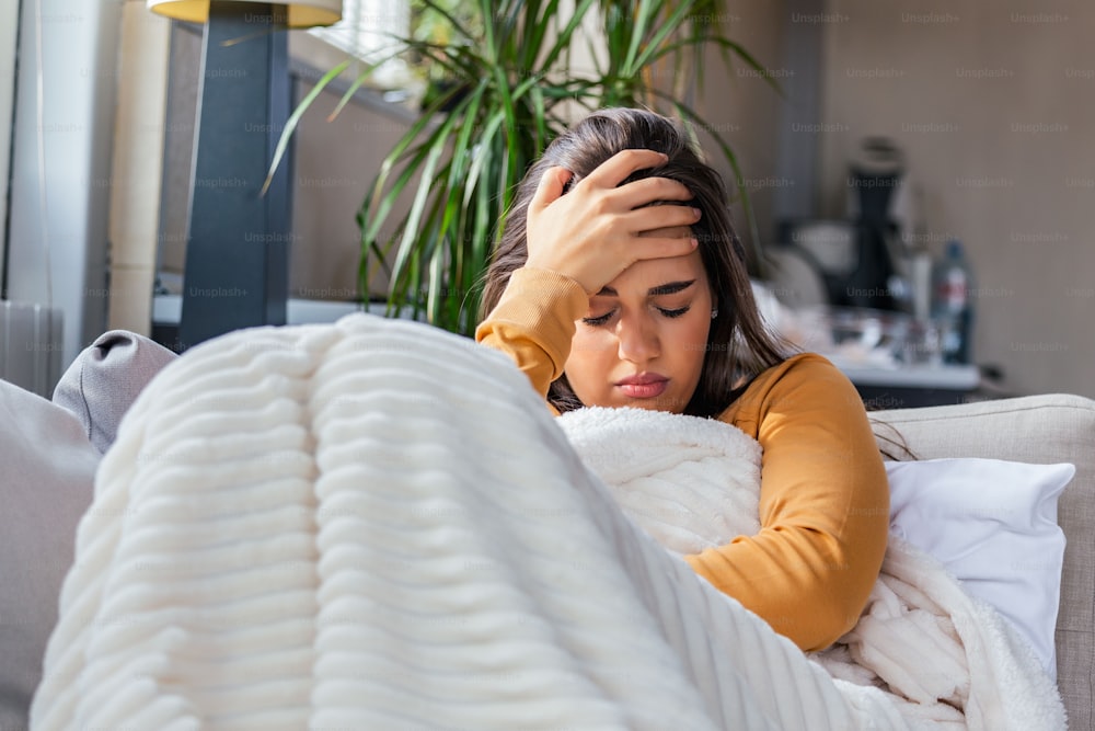 Sick desperate woman has flu. Rhinitis, cold, sickness, allergy concept. Pretty sick woman has runnning nose, rubs nose with handkerchief. Sneezing female. Brunette sneezing in a tissue