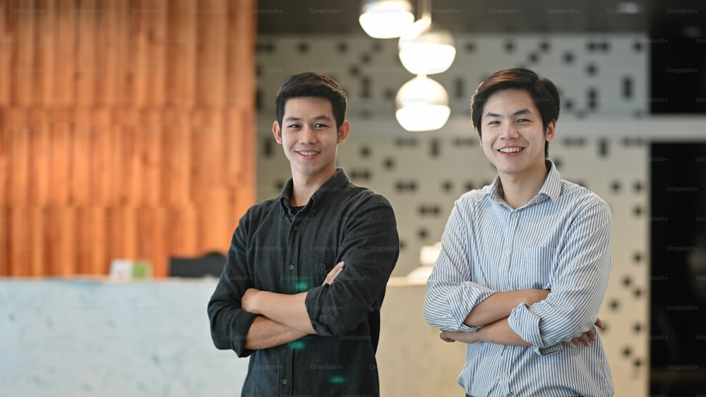 Causal young two businessman looking camera and front of information room.