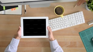 Top view workspace tablet holding on a man hands with above of table office desk.
