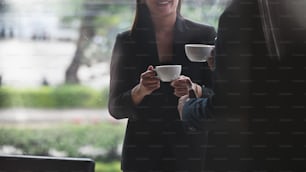 Cropped shot business people talking with coffee break.
