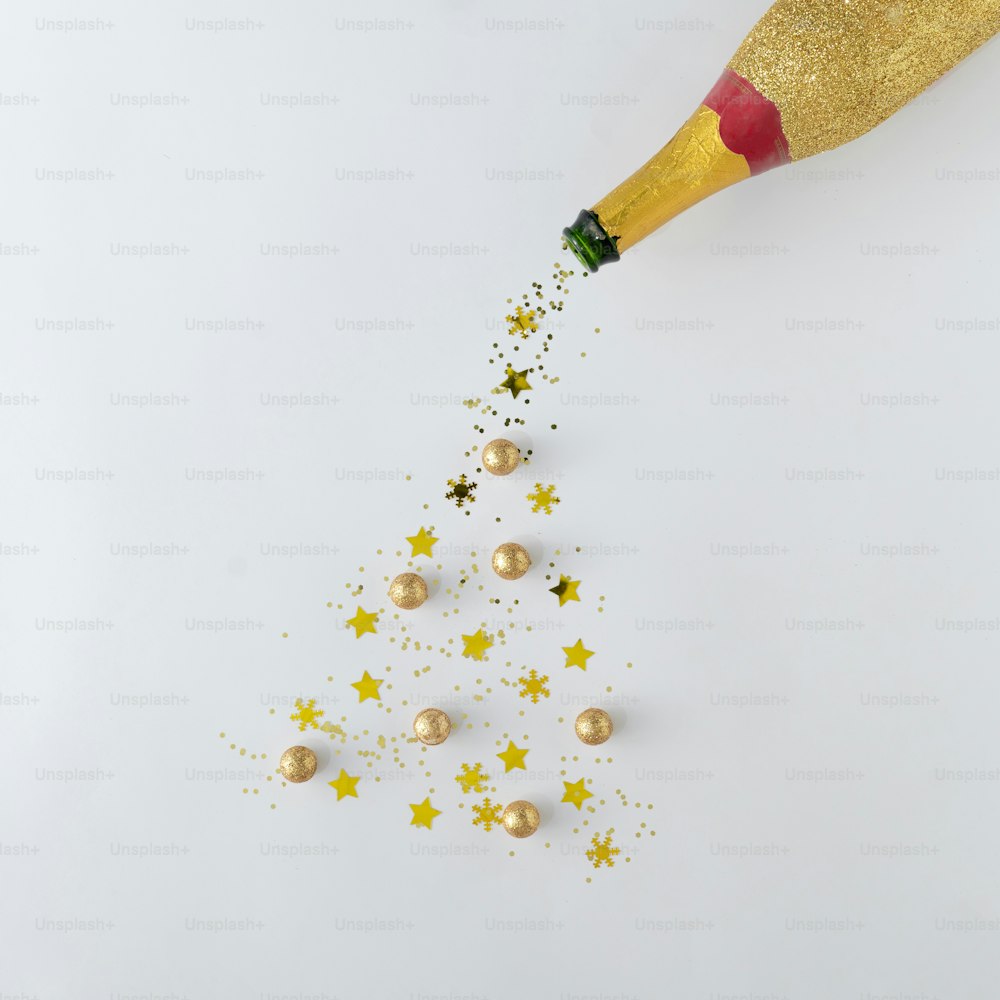 Champagne bottle with gold glitter Christmas tree. Minimal flat layt concept.
