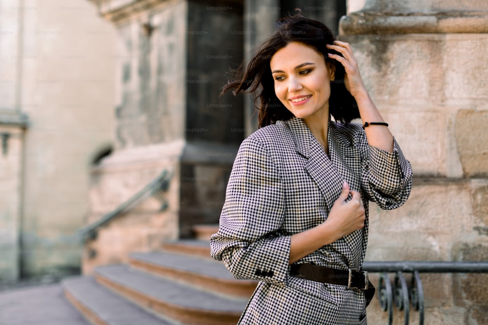 Stylish model woman with beautiful short hair and smile, standing at old  vintage building with stone stairs in city street . Gorgeous happy young  woman enjoying time and walk. photo – Fashion