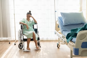 Paciente grave sentado en silla de ruedas en la sala del hospital. Los malos resultados de salud hacen que el paciente sea infeliz. Concepto de negligencia médica.