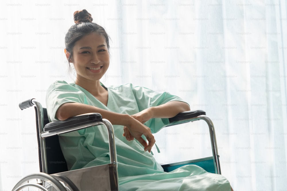 Glückliches Lächeln des Patienten im Rollstuhl nach der Genesung von einer Verletzung auf der Krankenstation. Medizinische Versorgung und gutes Patientenservicekonzept.