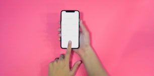 Nahaufnahme eines weiblichen Smartphones mit leerem Bildschirm und rosa Hintergrund