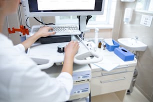Female is working with modern digital equipment in clinic and typing with mouse and keyboerd. Website banner
