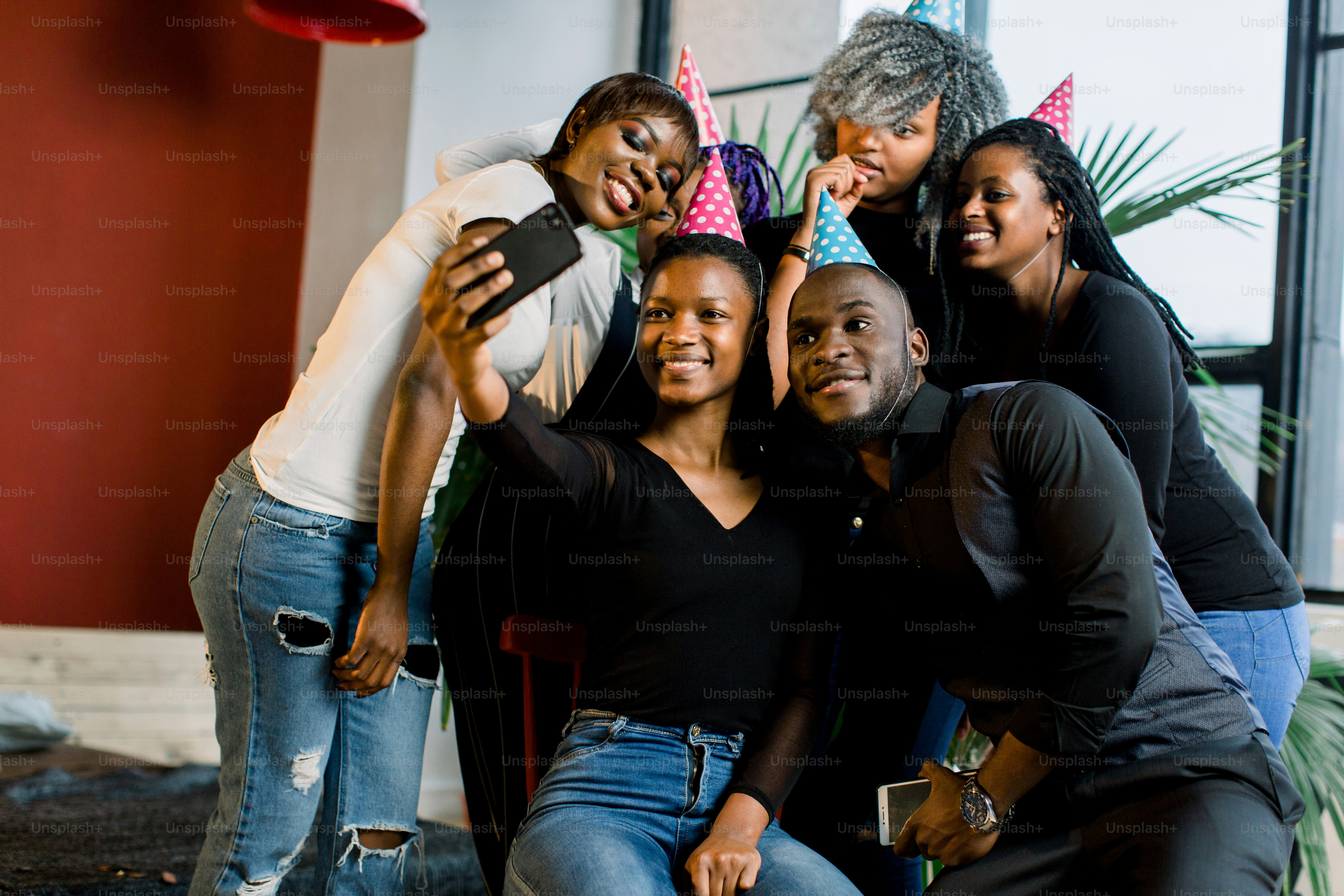 Gadis-gadis muda Afrika-Amerika yang cantik merayakan ulang tahun dan membuat selfii di ponsel cerdas mereka.
