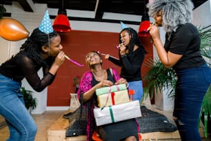 A beautiful smiling African girl opens a present at her birthday party