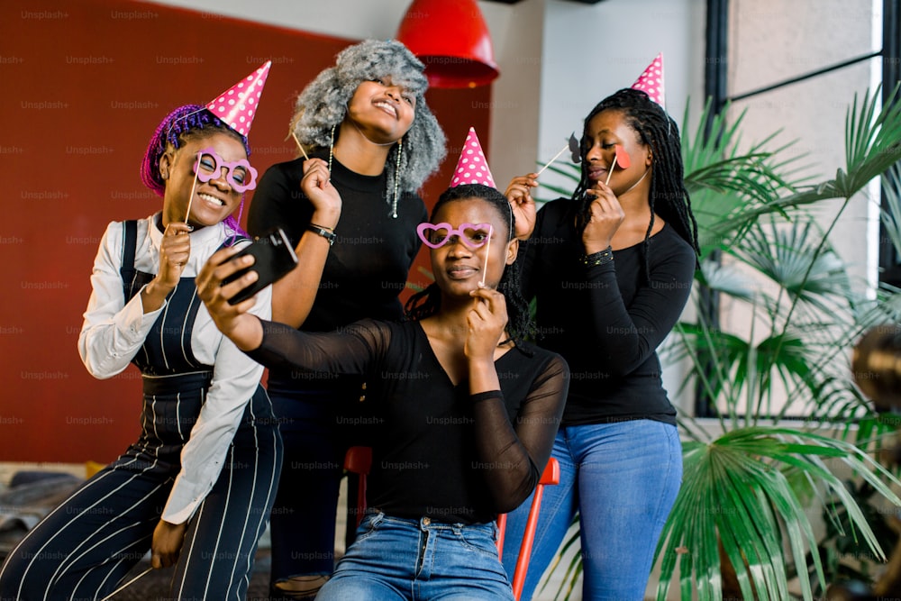 Afroamerikanische Mädchen feiern den Geburtstag ihrer Freundin, glücklich, lachen und machen Selfi