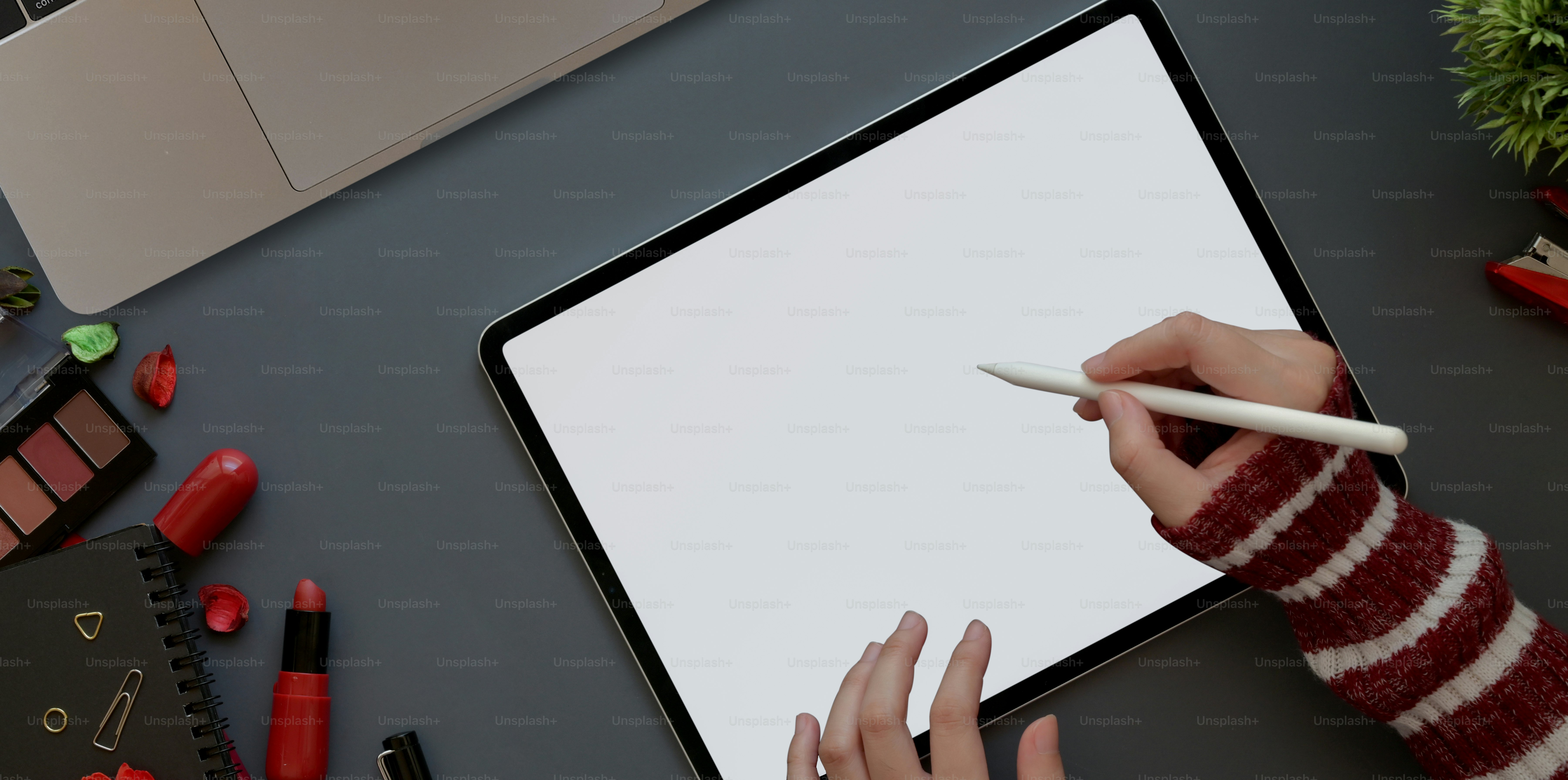 Feminine workspace with red luxury concept, top view of woman working with blank screen tablet