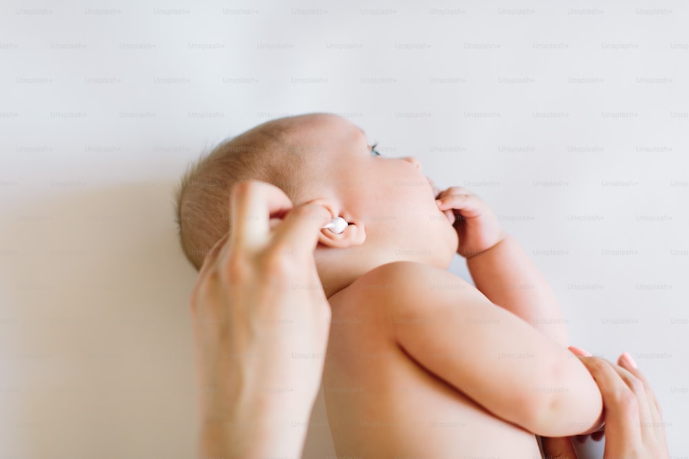 면봉으로 아기 귀를 청소하는 어머니.