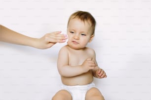 A mother cleaning baby skin, isolated on white background.