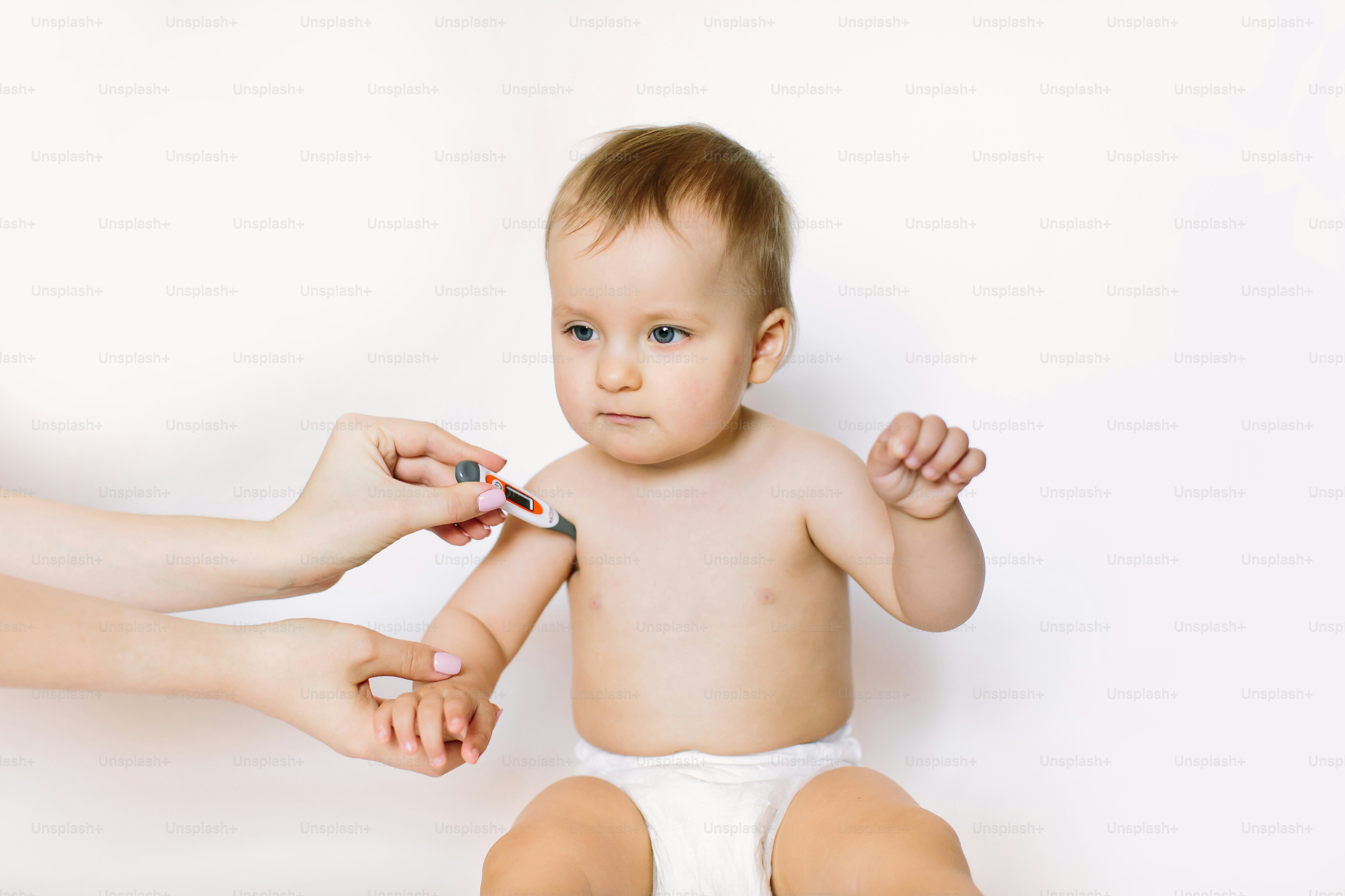 mother measures the temperature of a baby child kid.