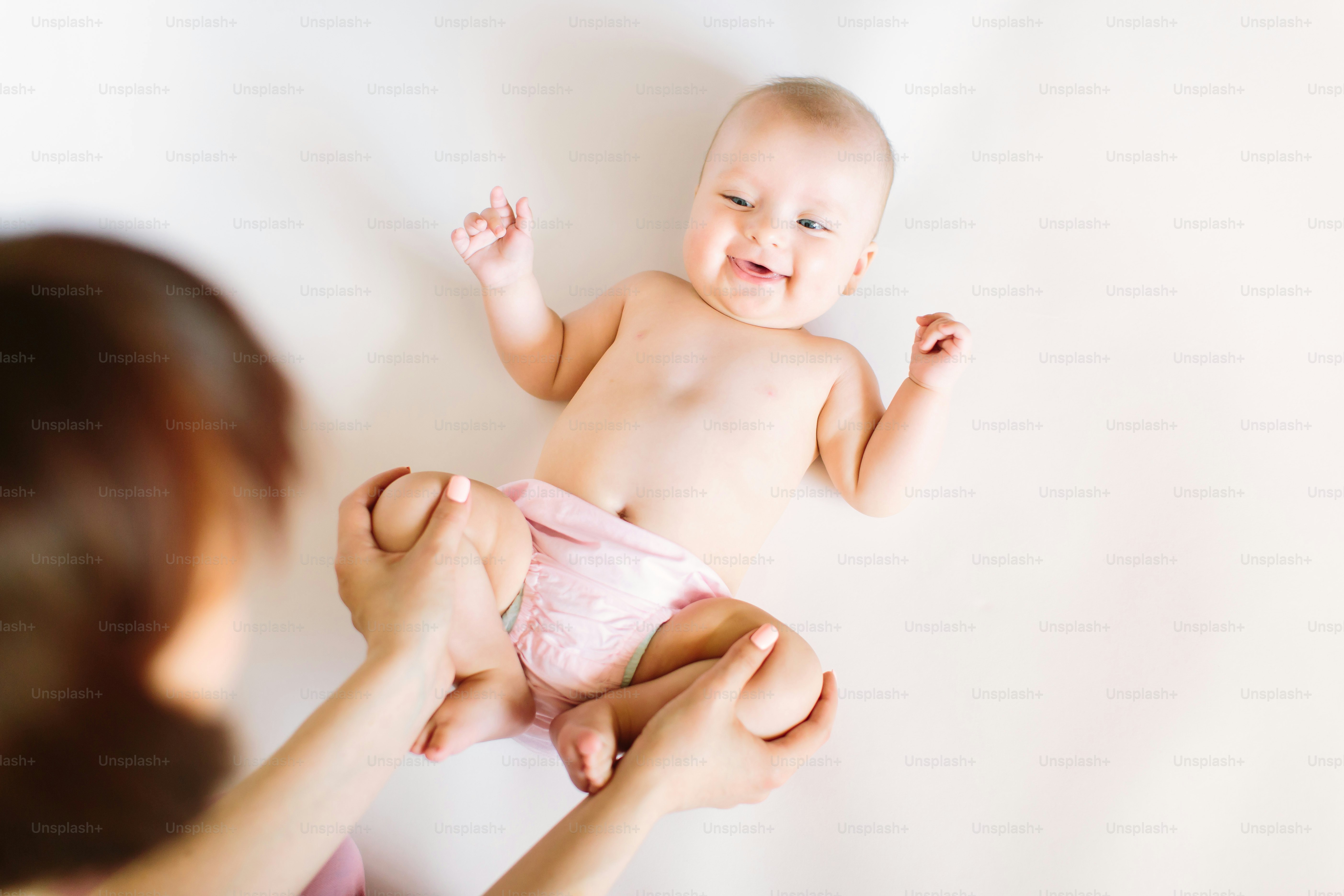 Baby massage. Mother massaging and doing gymnastic with legs of her kid