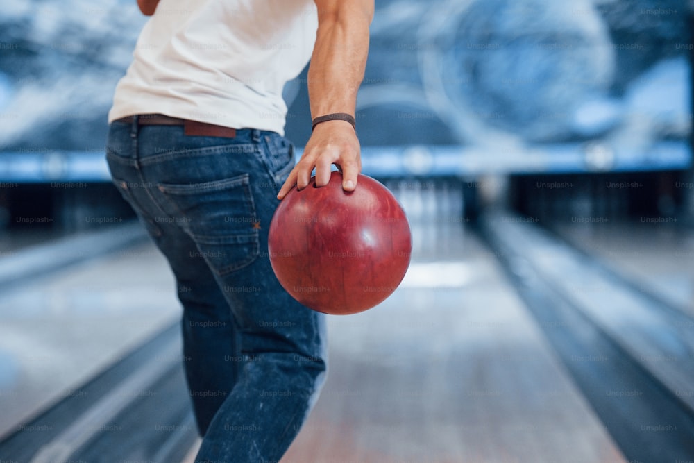 Conception of bowling. Rear particle view of man in casual clothes in the club.