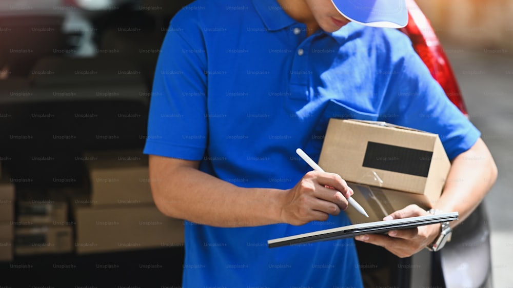 Cropped shot  man working with post man, Delivery man checking with boxes on his tablet computer.