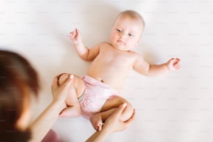 Baby massage. Mother massaging and doing gymnastic with legs of her kid.