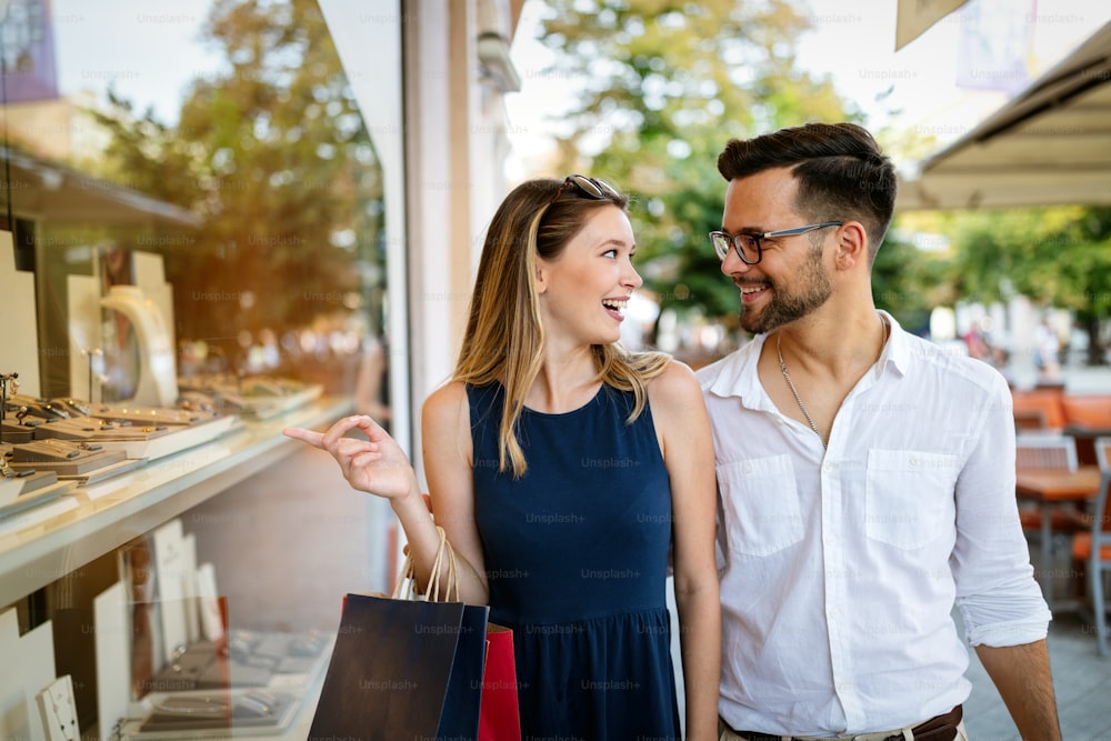 Consumerism, love, dating, travel concept. Happy couple enjoying shopping having fun