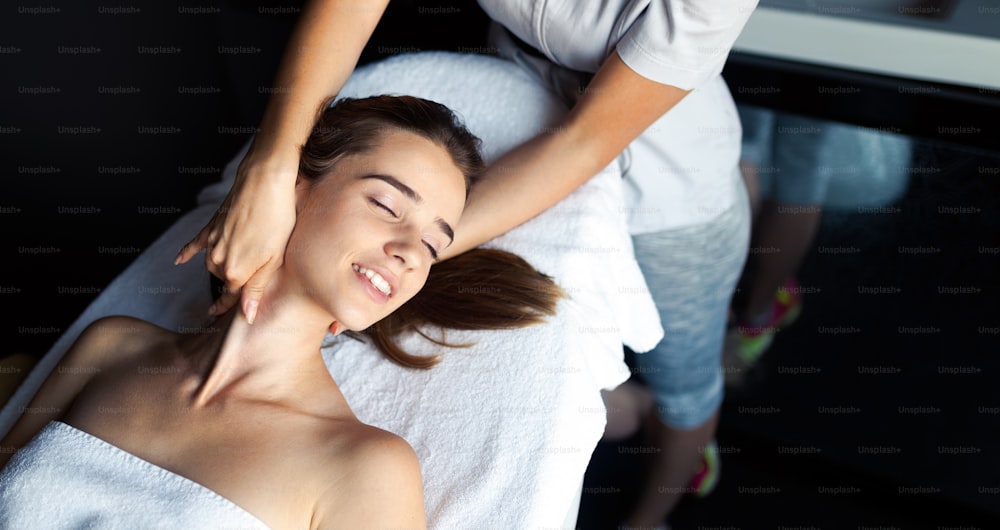 Massaggiatore che fa massaggio sul corpo della donna nel salone termale. Concetto di trattamento di bellezza.