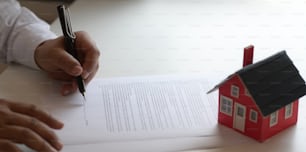 Close-up view of customer signing contract about home loan agreement, property real estate concept