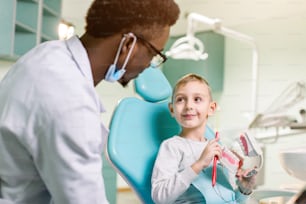 Dentista examina os dentes do menino. Profilaxia de cárie, dentes de leite, pediatria