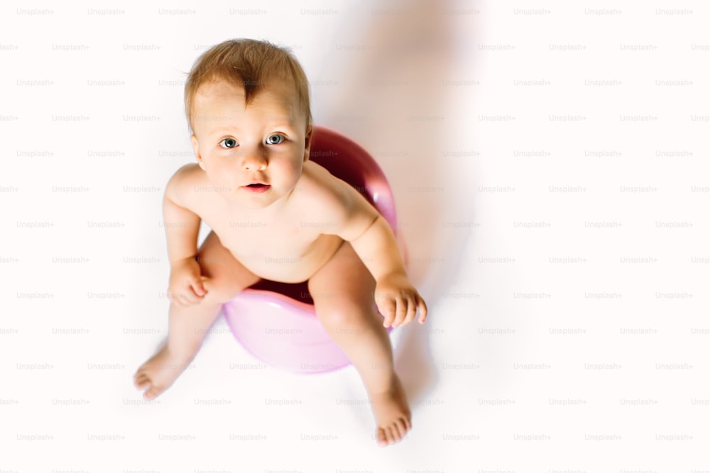 smiling baby toddler sitting on chamber pot.