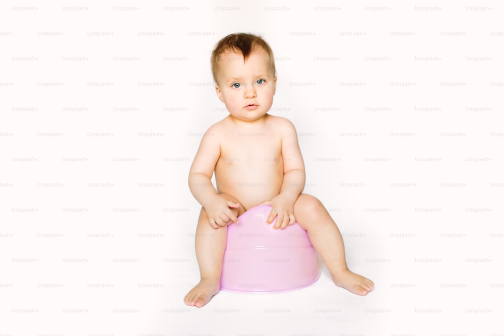 smiling baby on chamber-pot. isolated on white background.