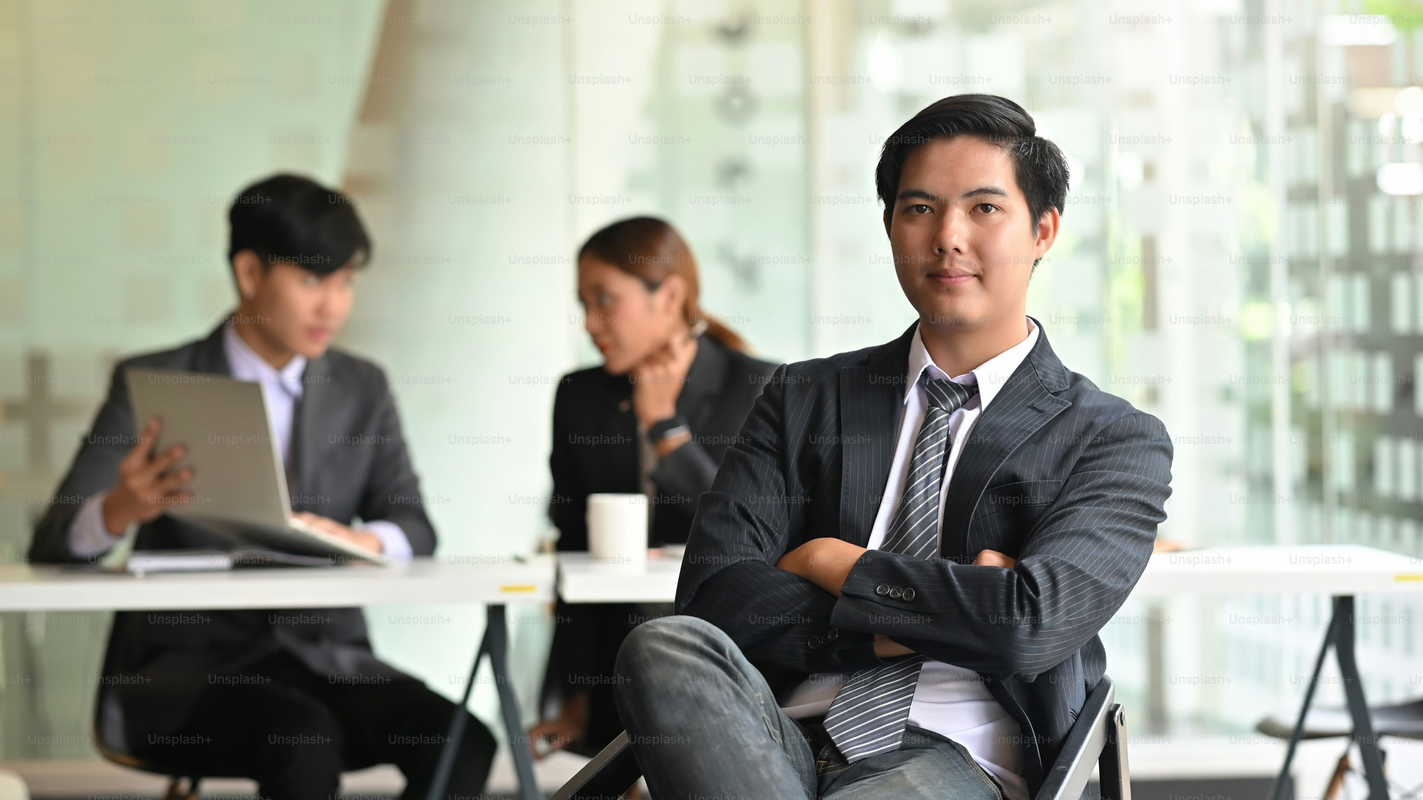 Confidently young businessman looking at the camera and sitting front ...