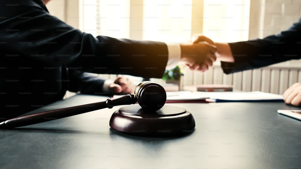 Businessman shaking hands to seal a deal with his partner lawyers or attorneys discussing a contract agreement and lawsuit.