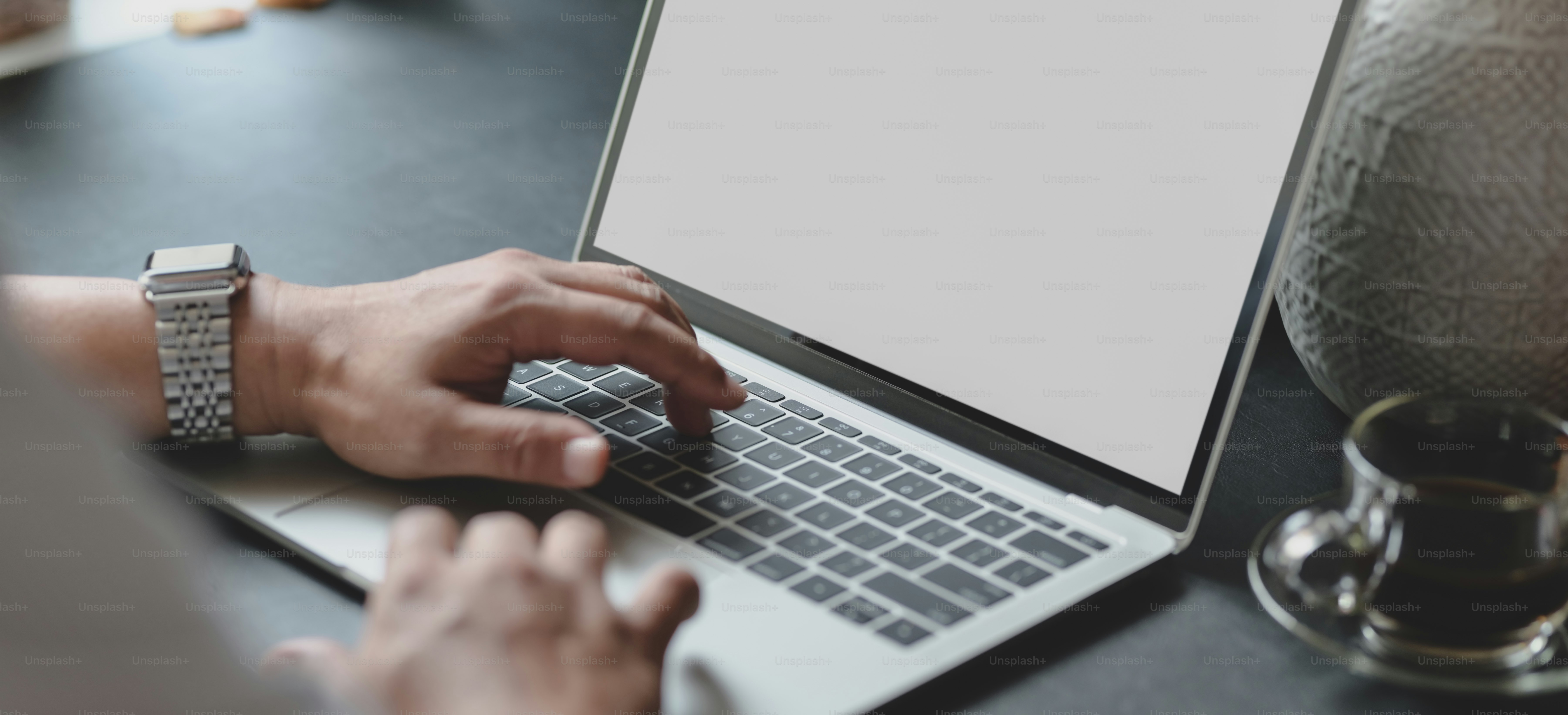 Cropped shot of businessman typing on laptop computer while working on his project