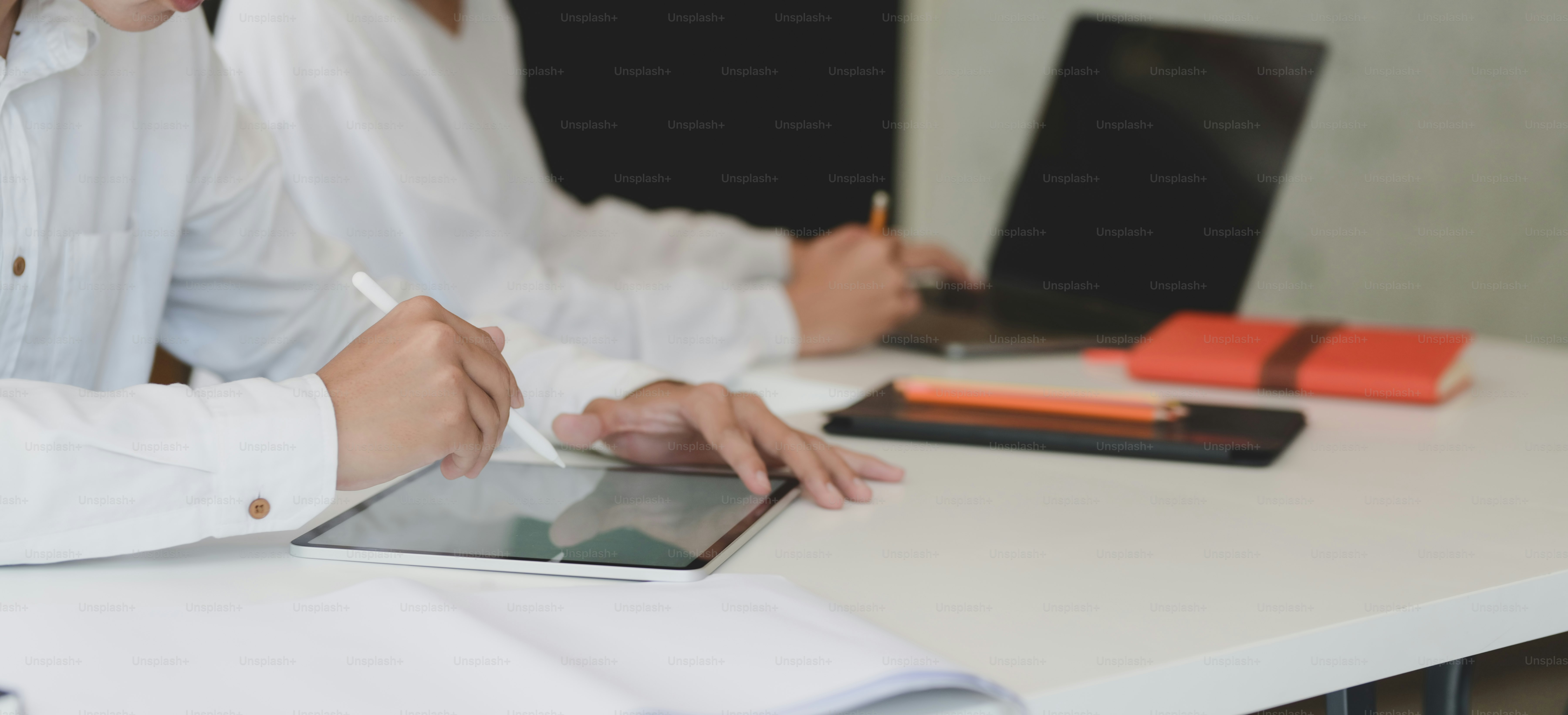 Cropped shot of two professional business partner discussing their project together while using tablet