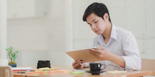 Close-up view of young male designer planing his project with tablet in his workplace