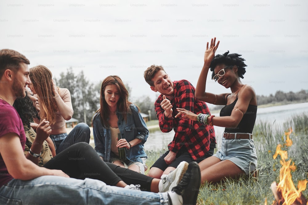 Feeling the rhythm. Group of people have picnic on the beach. Friends have fun at weekend time.