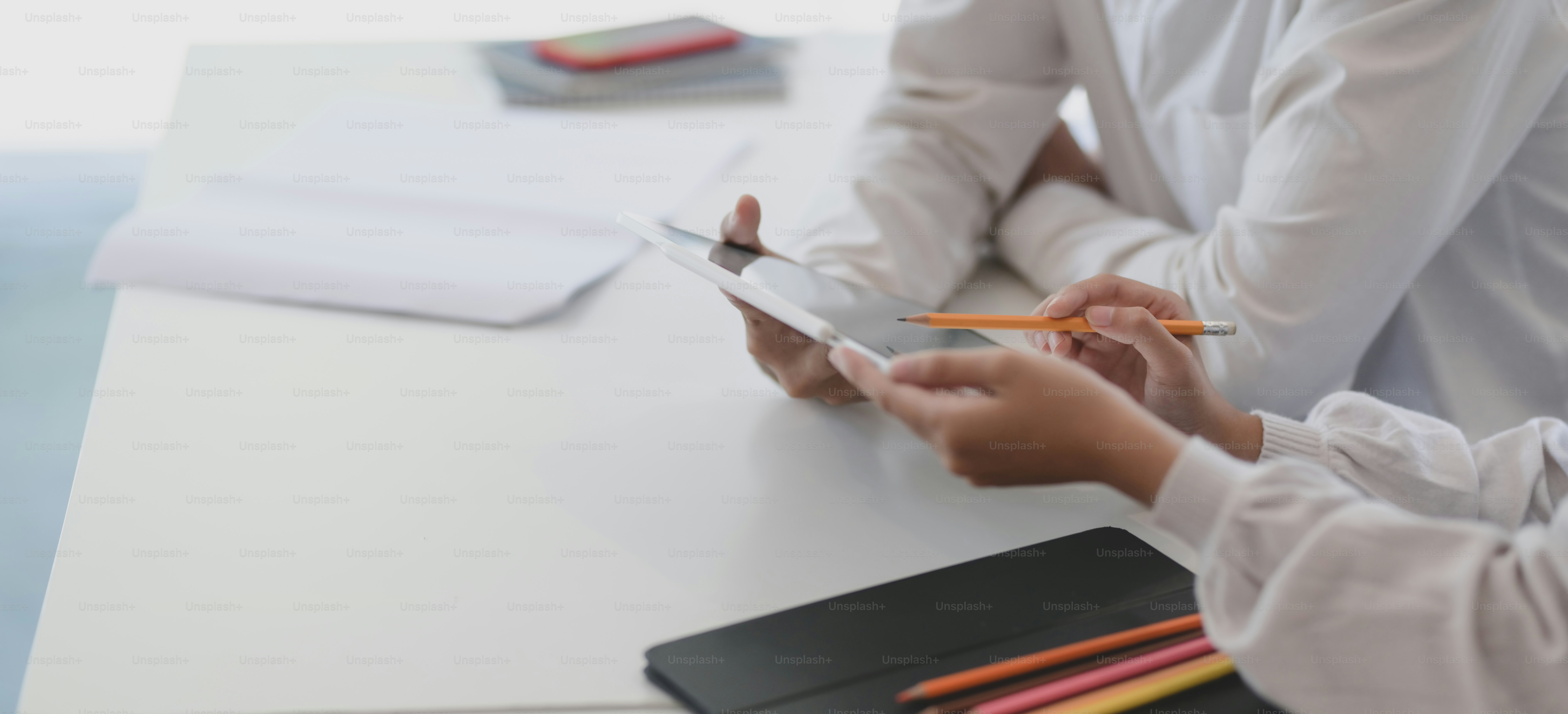 Cropped shot of professional business team discussing their project together while using tablet