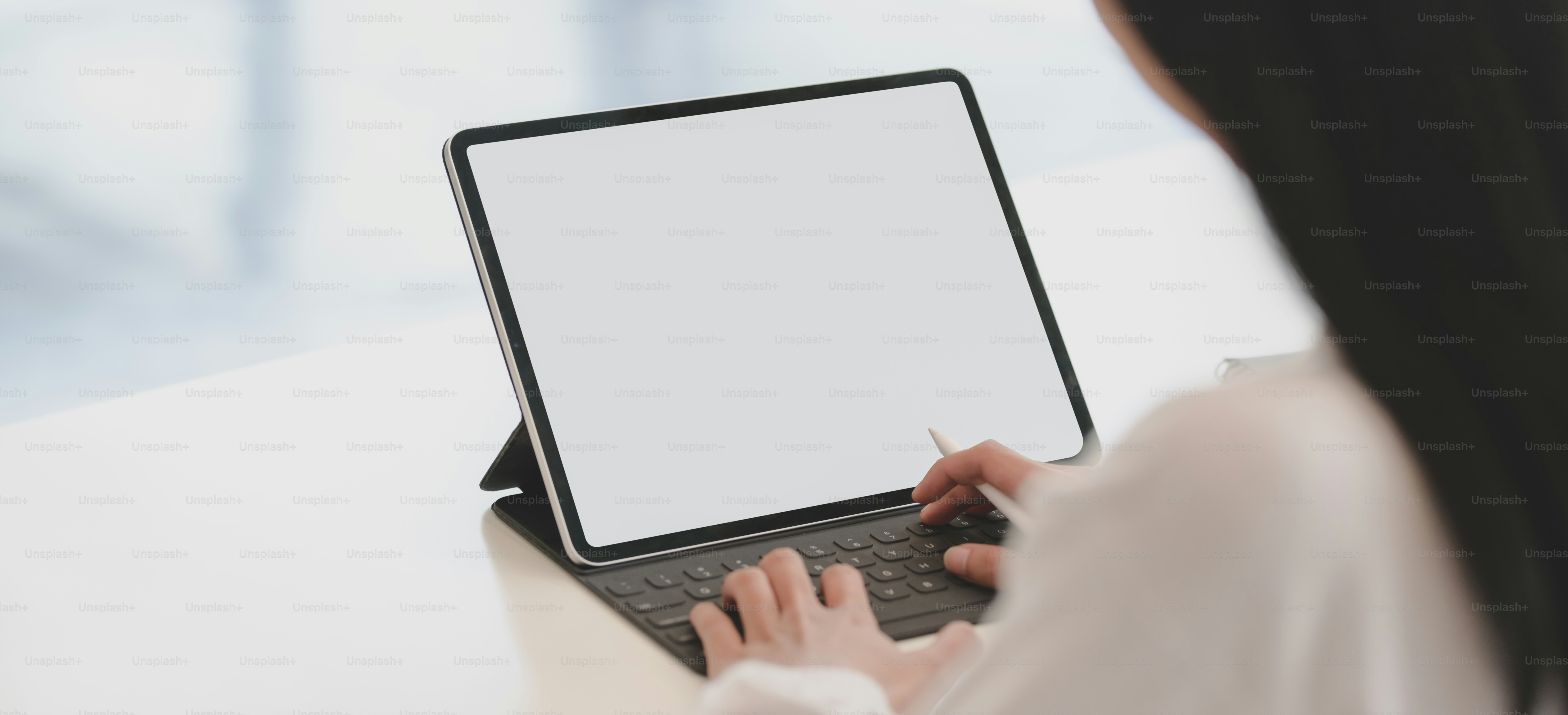 Cropped shot of young businesswoman working on her project while using tablet in modern office room