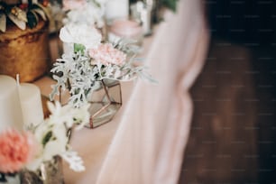 웨딩 테이블에 세련 된 고급 장식입니다. 분홍색 중앙 장식에 현대 유리 꽃병에 흰색 꽃입니다. 고급 케이터링 및 장식. 휴일 축제