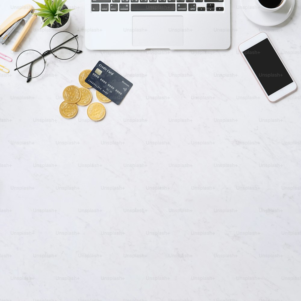 Concept de paiement en ligne avec carte de crédit avec téléphone intelligent, ordinateur portable sur bureau sur fond de table en marbre clair propre, vue de dessus, pose à plat