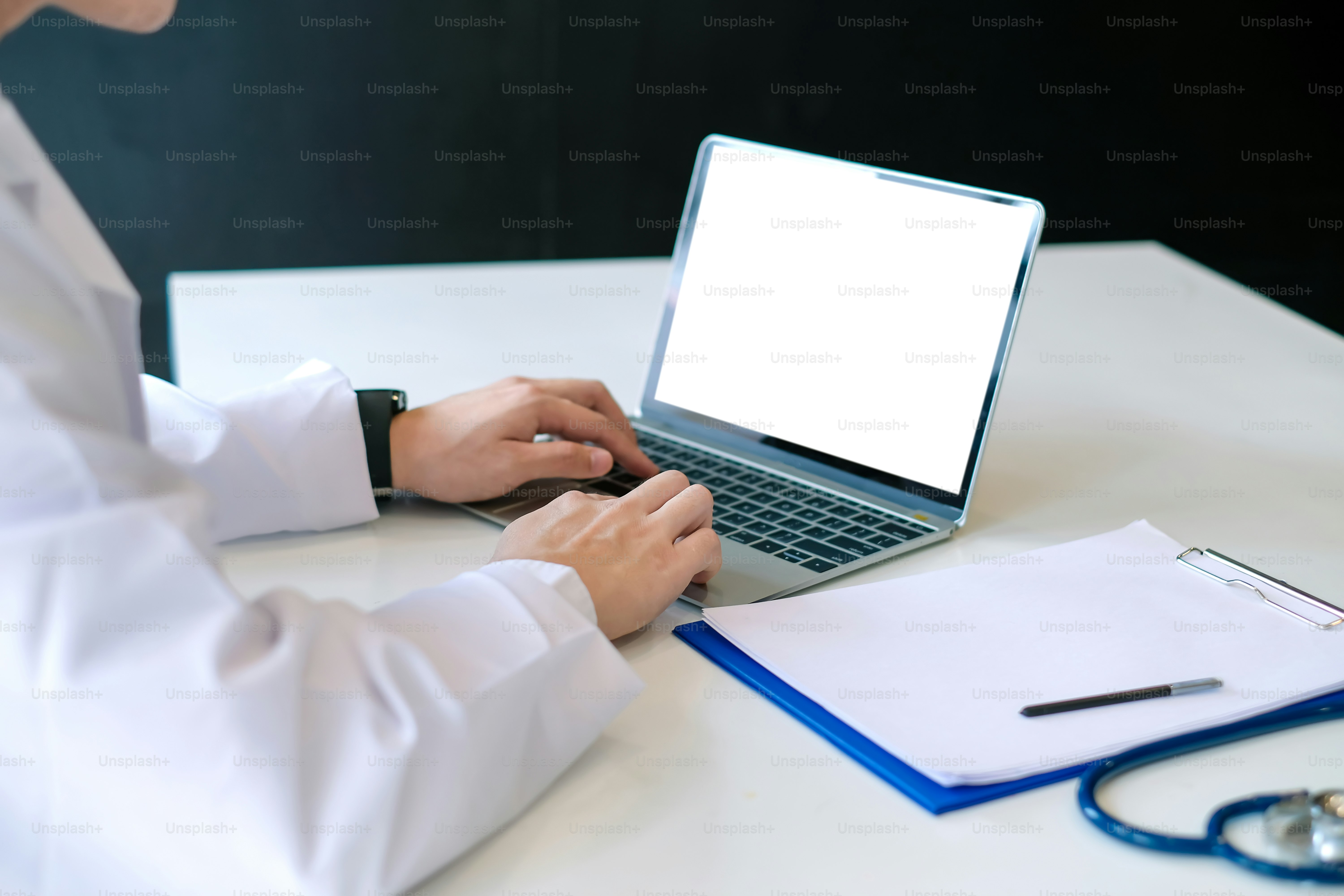 Mock up. Doctor working with laptop computer and see patient record in document.